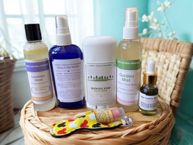 Collection of Linda's Natural Remedies personal care products including mists, deodorants, and lip balms displayed on a wicker basket.