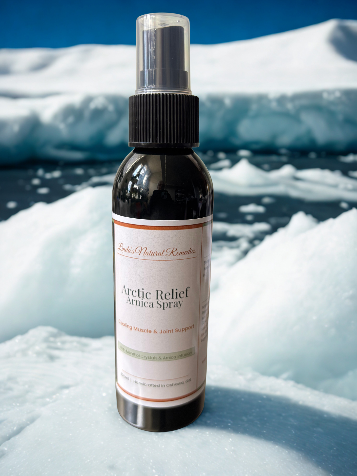 Lifestyle photo of Arctic Relief Arnica Spray by Linda's Natural Remedies, a handcrafted cooling topical for muscle and joint support. Featuring the copper and sage green artisan label design.