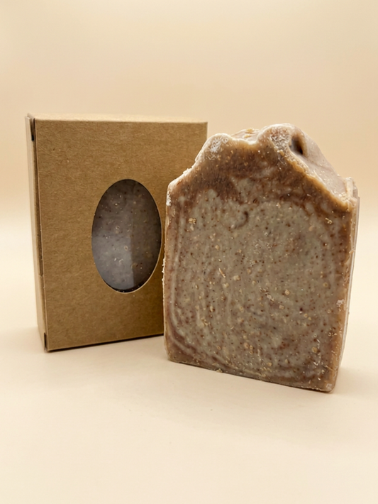 Bar of soap next to a cardboard box on a beige background