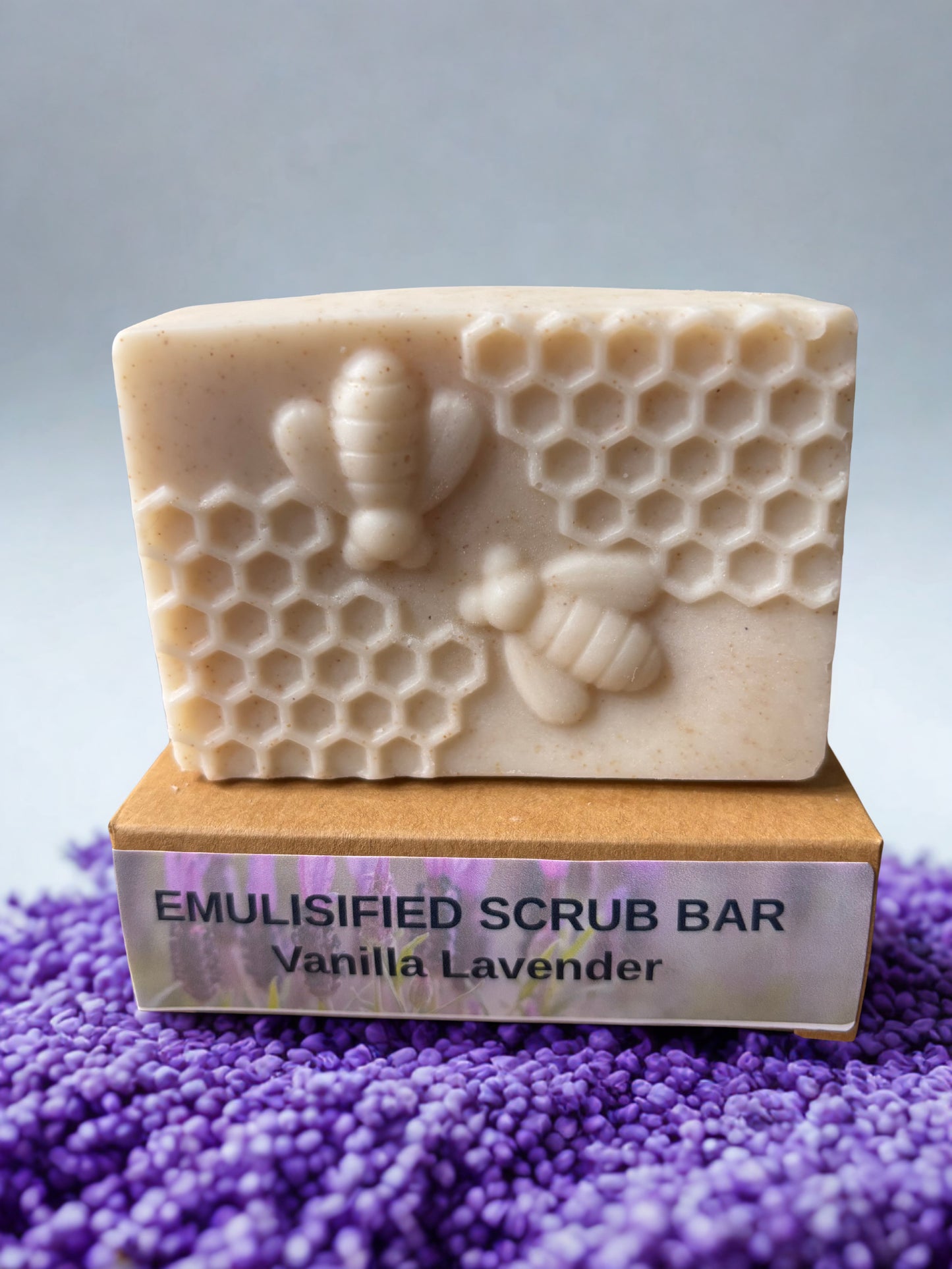 Emulsified scrub bar with honeycomb and bee design on a purple textured surface