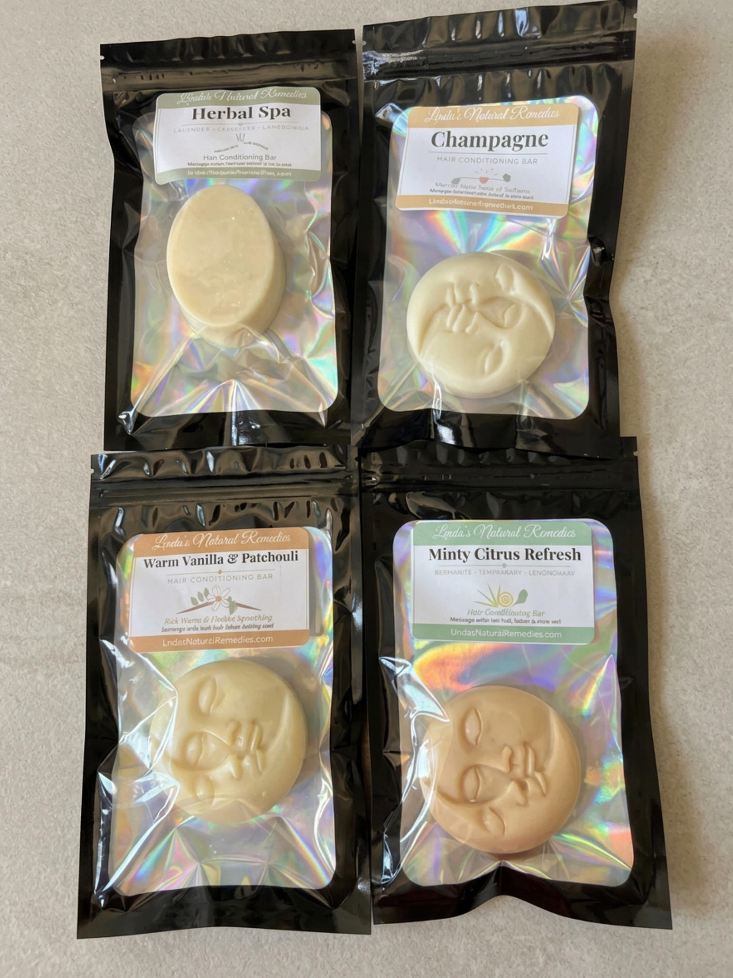 Four packages of soap with different scents on a neutral background