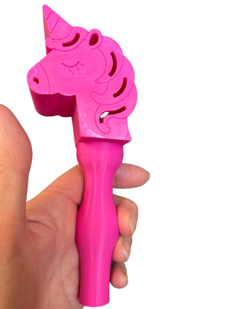 Pink unicorn-shaped wand held in a hand against a white background
