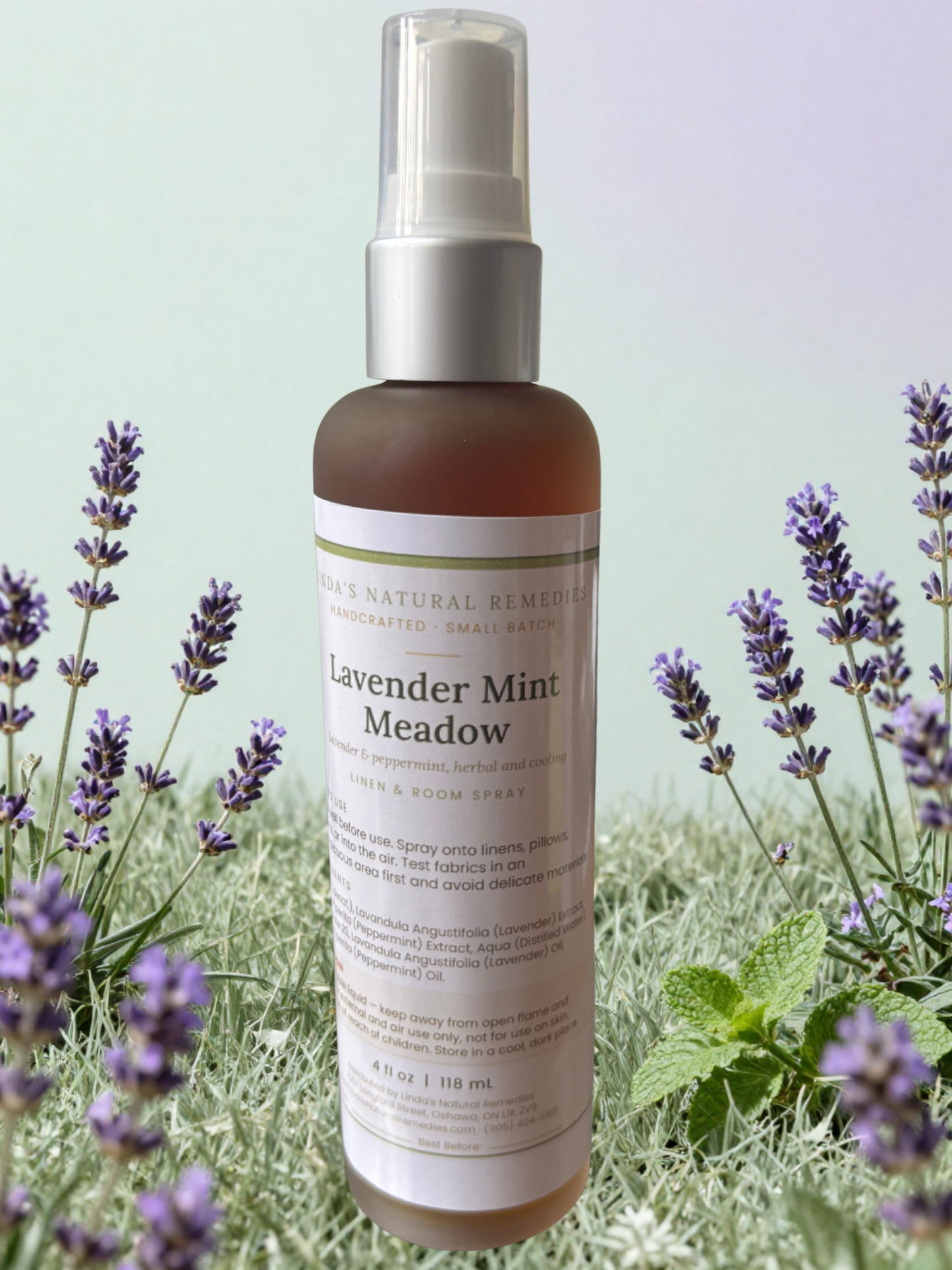 Lavender Mint Meadow room spray bottle with label, placed among lavender stems in a meadow setting