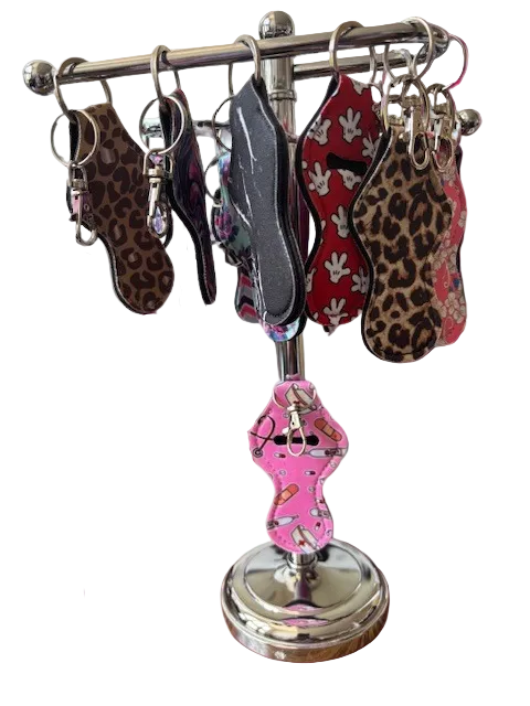 Colorful fabric lip balm holders with metal keychain clips, shown in a variety of patterns.