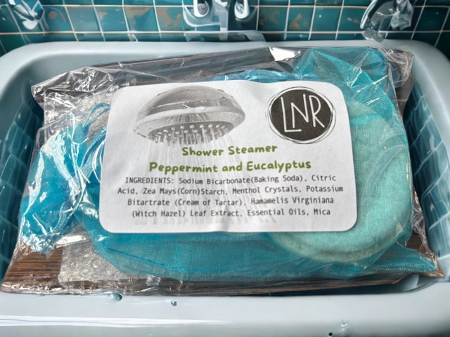 Green-tinted menthol shower steamer for sinus relief and respiratory comfort.
