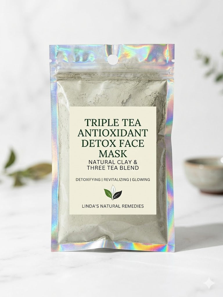 A holographic pouch of Triple Tea Antioxidant Detox Face Mask by Linda's Natural Remedies on a white marble surface with a wooden spoon.