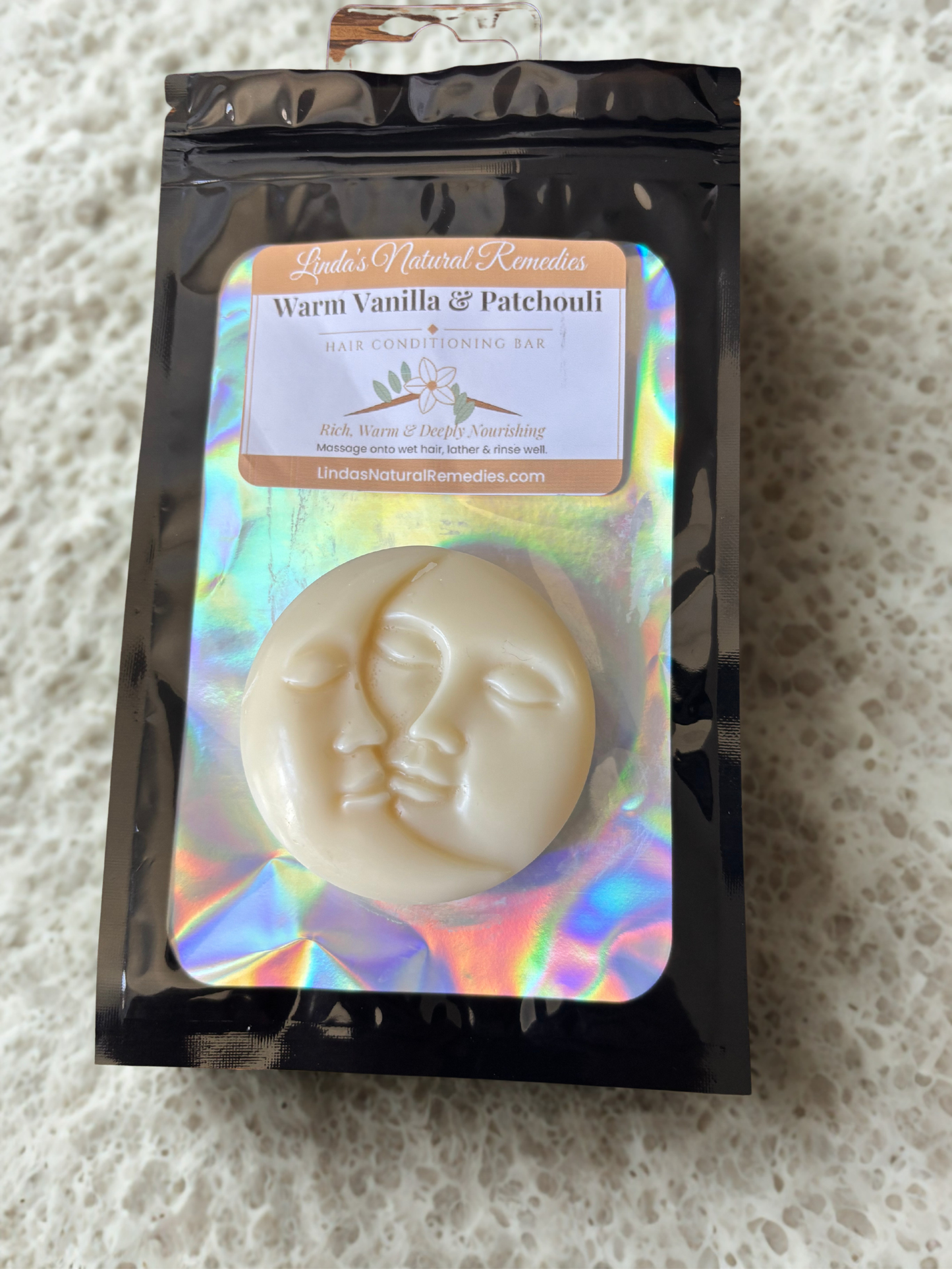 Soap bar with face design in a branded packaging on a textured surface