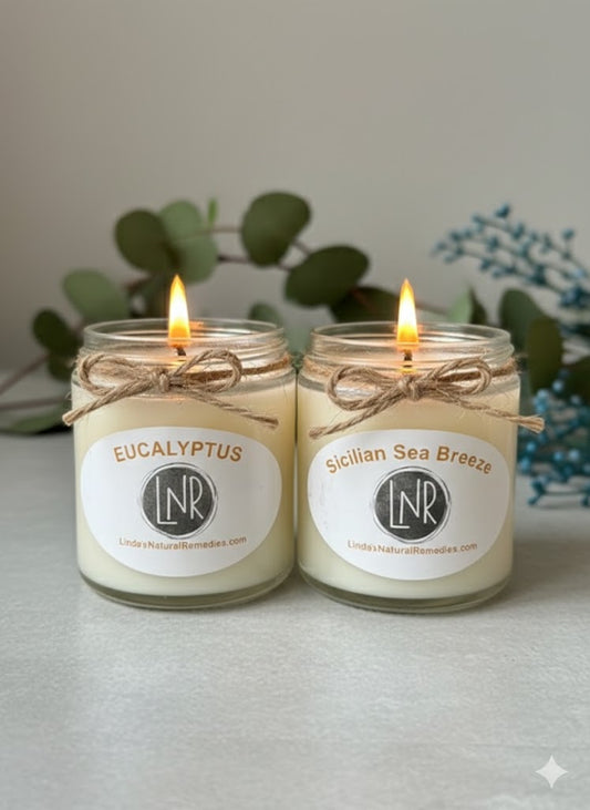 Two lit candles in glass jars with labels on a neutral background