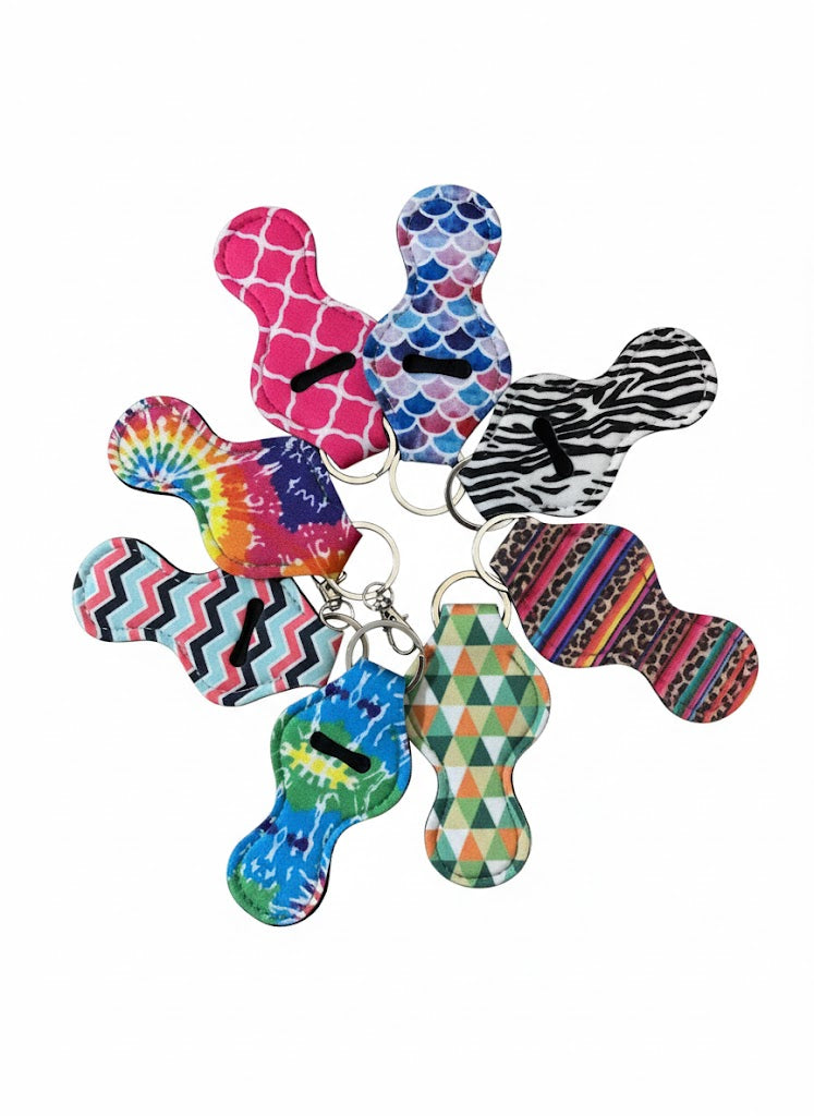 "Lip balm holders featuring modern geometric patterns like chevrons, scales, and triangles, displayed in a circular arrangement on a clean white background."