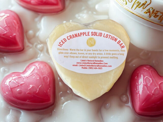 Artisan gift-wrapped Iced Cranapple Lotion Bar. A heart-shaped 90g solid moisturizer protected by hand-folded wax paper, perfect for natural skin care gifting.