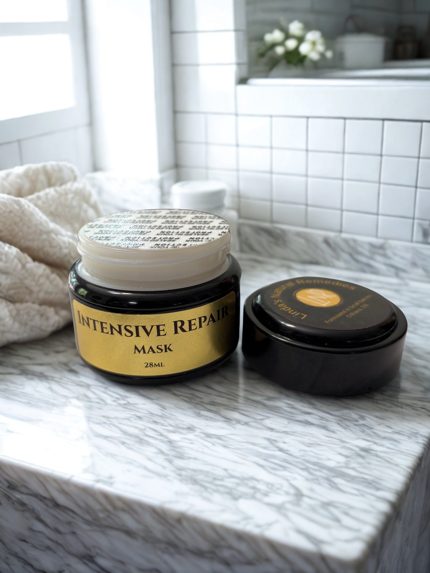 Intensive Repair Mask jar on a marble surface with a towel and blurred background