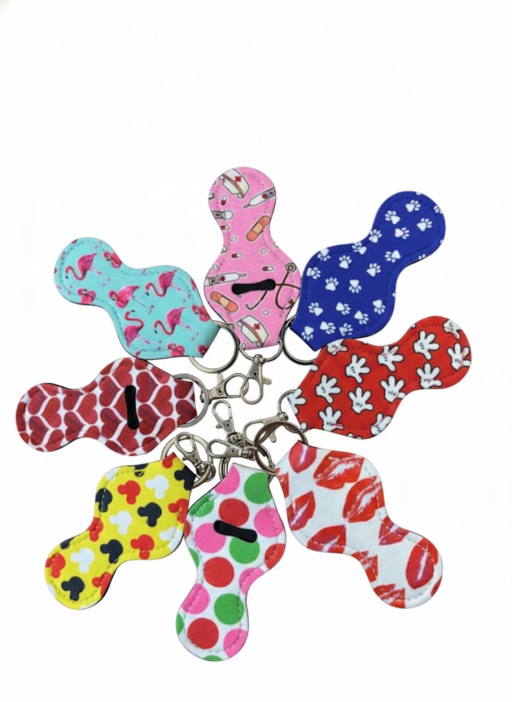 "A collection of whimsical lip balm holders with fun prints including flamingos, hearts, and paw prints, shown on a professional white background."